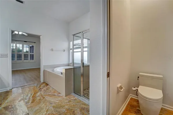 a bathroom with a granite countertop toilet and a sink