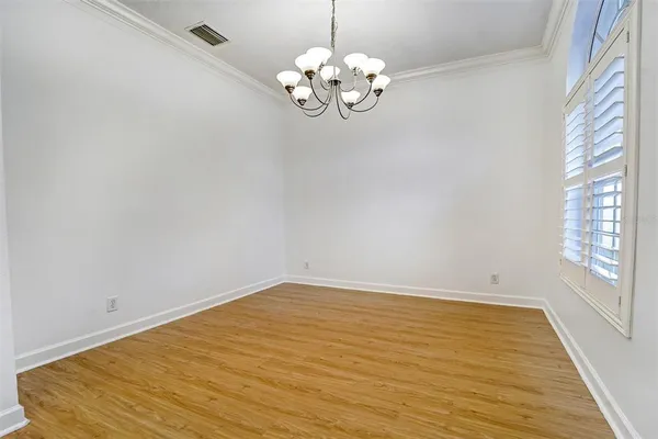 a view of a room with wooden floor and chandelier