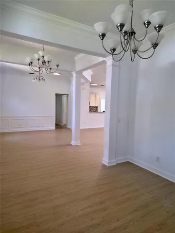 a view of a room with chandelier fan and wooden floor