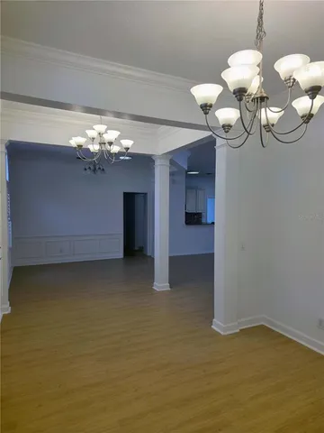 a view of a room with chandelier fan and wooden floor