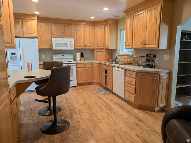 1411 Millbrook Way Bountiful, UT 84010 - Photo 10 of 36 Spacious kitchen featuring light wood cabinetry, light-toned countertops, and wood-finish flooring