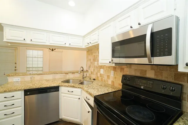 a kitchen with granite countertop a stove and a sink