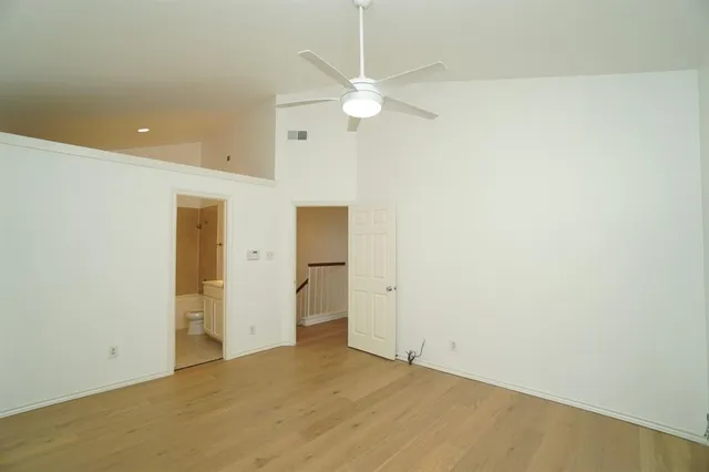 an empty room with a ceiling fan and closet area
