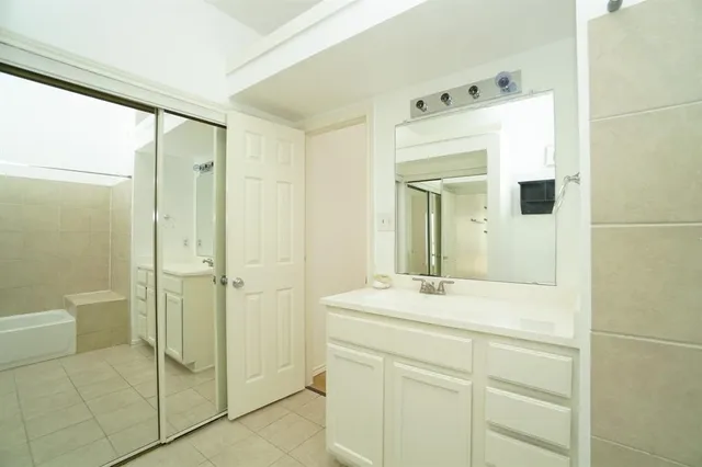 a bathroom with a shower sink and mirror