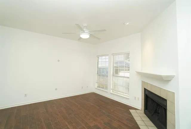 an empty room with wooden floor and a fireplace