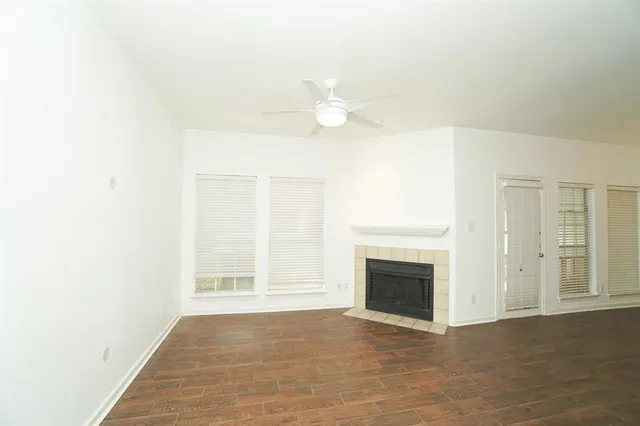an empty room with windows and fireplace