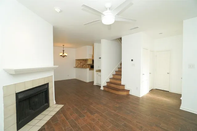 an empty room with wooden floor and a fireplace