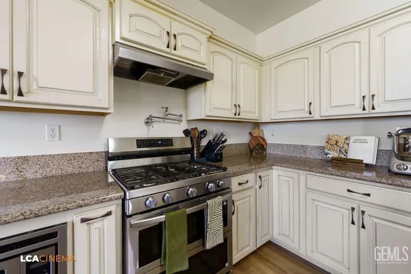 a kitchen with granite countertop white cabinets and stainless steel appliances