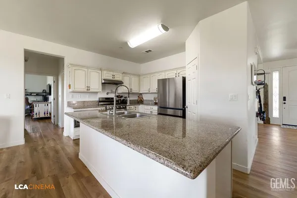 a kitchen with stainless steel appliances granite countertop a sink a stove and a refrigerator