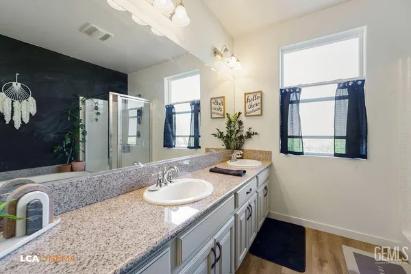 a bathroom with a sink double vanity granite and a mirror