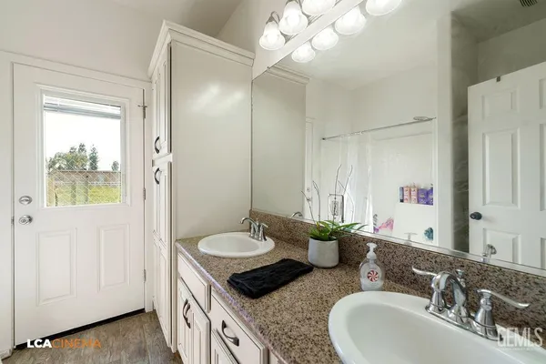 a bathroom with a granite countertop sink and a mirror
