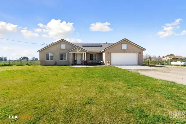 a view of a house with a yard and potted plants