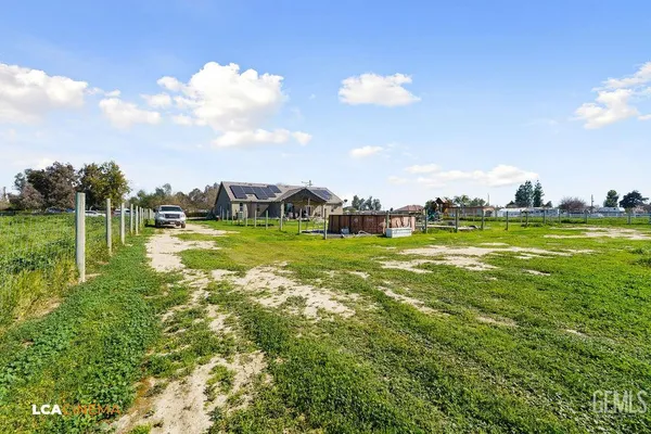 a view of a ocean with a big yard and large trees