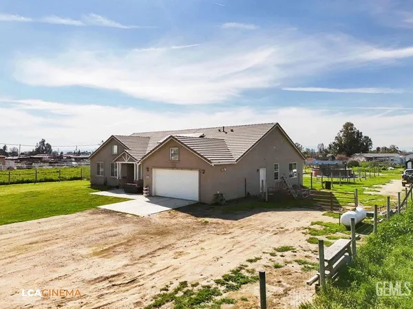 a front view of a house with a yard and ocean view