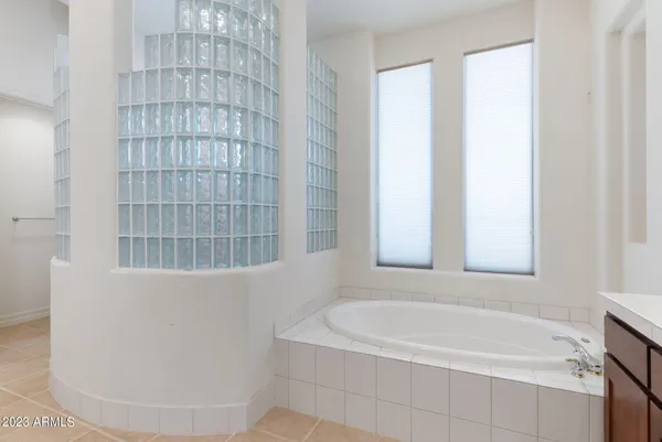 a bathroom with a granite countertop sink a mirror a shower and a bathtub