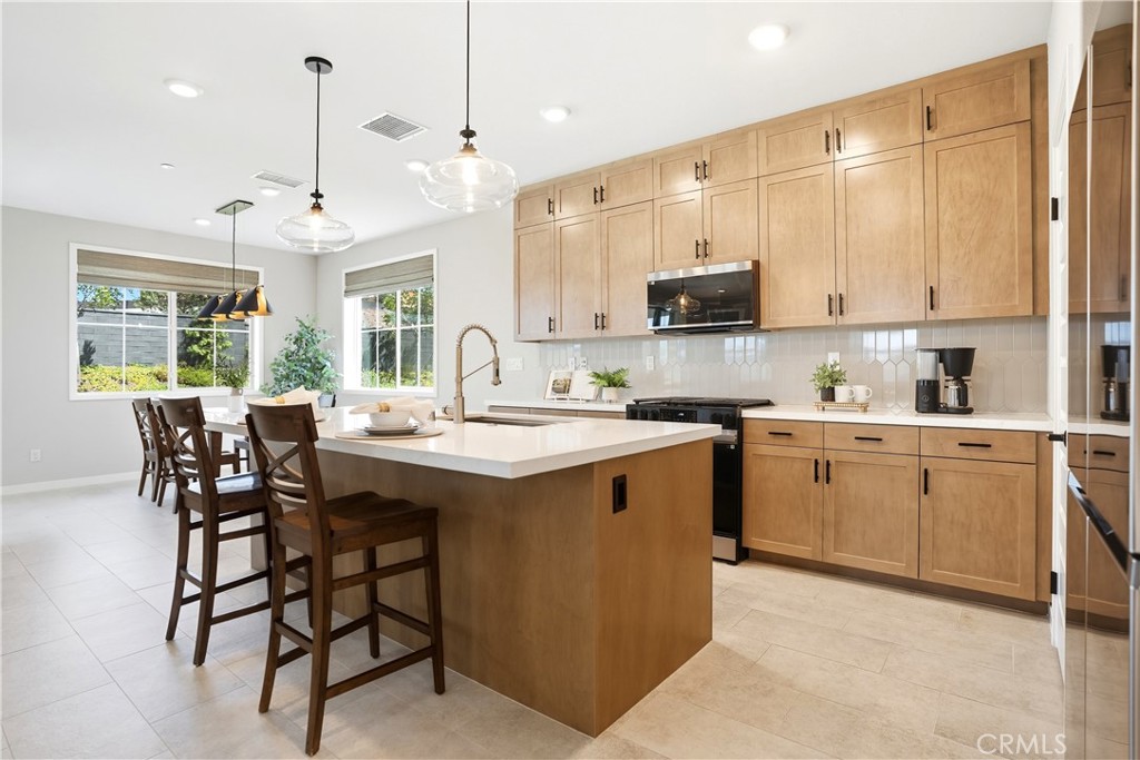 1341 Roots Way Rancho Mission Viejo, CA 92694 - Photo 12 of 75 a kitchen with kitchen island granite countertop a sink counter top space and stainless steel appliances
