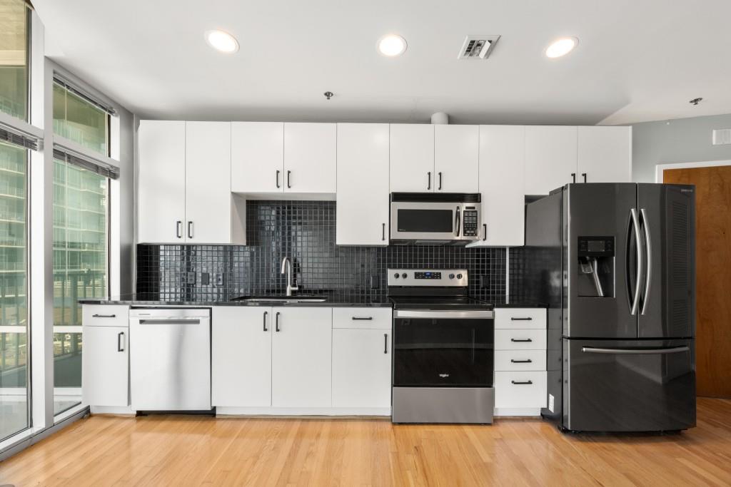 923 Peachtree Street Northeast, Unit 932 Atlanta, GA 30309 - Photo 7 of 69 a kitchen with stainless steel appliances a refrigerator sink and microwave