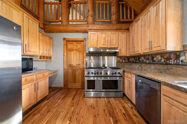 a kitchen with stainless steel appliances granite countertop a stove a sink and a refrigerator