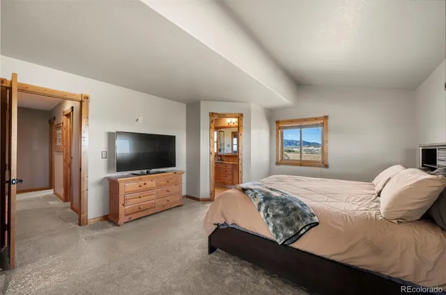 a bedroom with bed and a flat screen tv