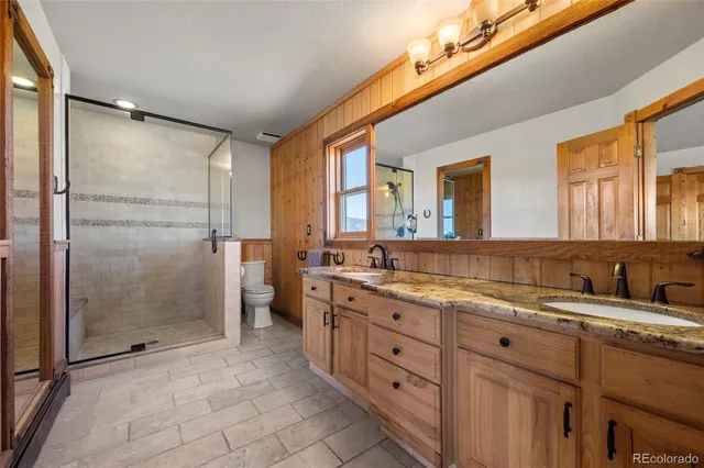 a spacious bathroom with a granite countertop sink mirror and shower