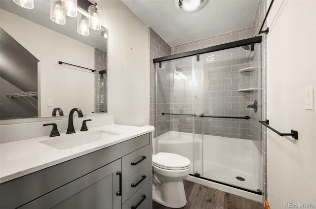 a bathroom with a sink a toilet and shower