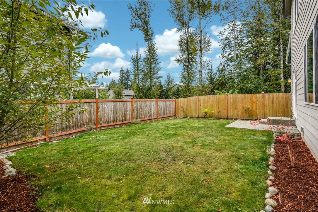15809 Meridian Avenue South Bothell, WA 98012 - Photo 29 of 32 a view of a backyard with large trees and wooden fence