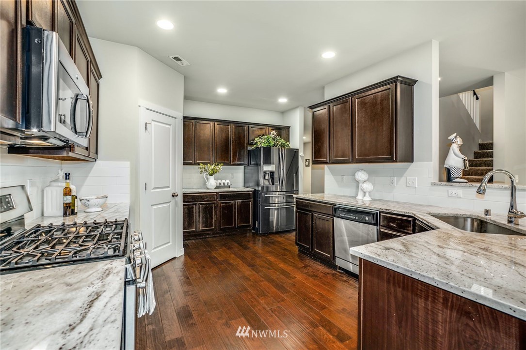 15809 Meridian Avenue South Bothell, WA 98012 - Photo 10 of 32 a kitchen with kitchen island granite countertop stainless steel appliances and sink