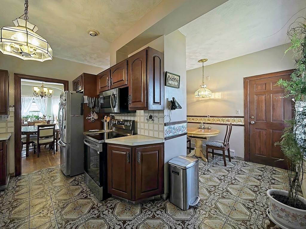 20 Locust Street Everett, MA 02149 - Photo 11 of 39 a kitchen with stainless steel appliances granite countertop a sink stove and refrigerator