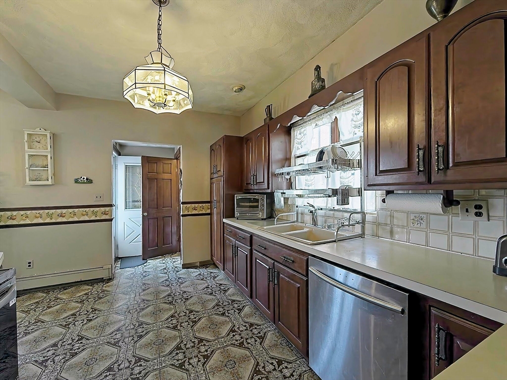 20 Locust Street Everett, MA 02149 - Photo 14 of 39 a kitchen with stainless steel appliances granite countertop a sink stove and refrigerator