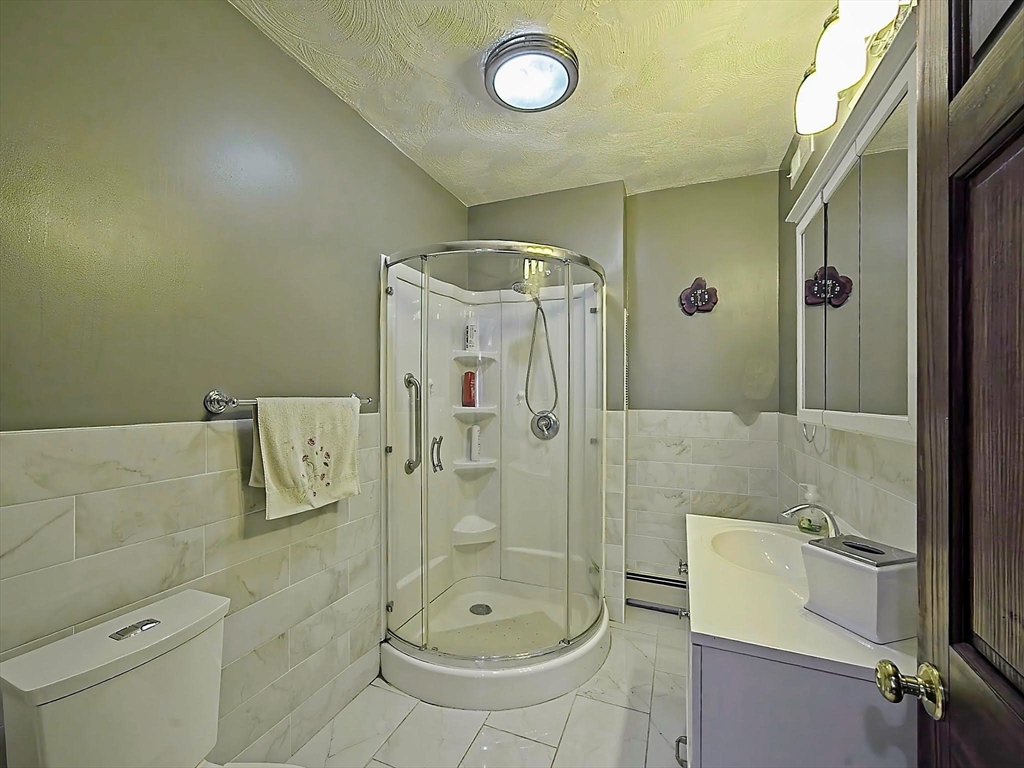 20 Locust Street Everett, MA 02149 - Photo 17 of 39 a bathroom with a shower a mirror and a sink