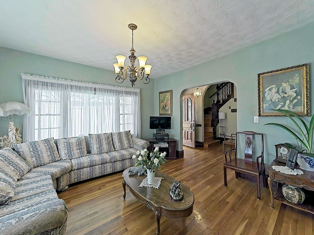 20 Locust Street Everett, MA 02149 - Photo 9 of 39 a living room with furniture chandelier and wooden floor
