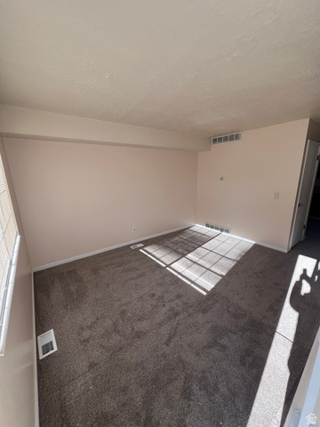 556 North Fairfield Road, Unit D4 Layton, UT 84041 - Photo 5 of 23 Carpeted spare room with baseboards and a textured ceiling