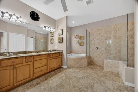 a large bathroom with a granite countertop sink a toilet a mirror and shower