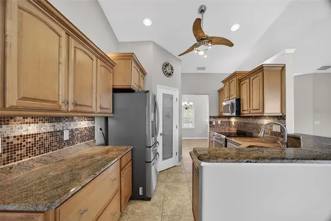a kitchen with stainless steel appliances granite countertop a sink a stove and a refrigerator