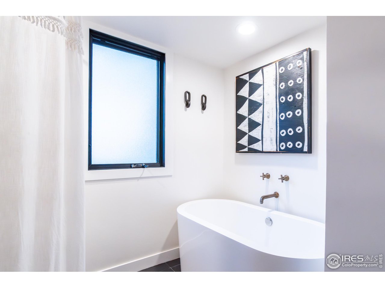 6474 Redwing Place Longmont, CO 80503 - Photo 4 of 11 a bathroom with a bathtub a shower and a sink