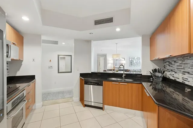 a kitchen with stainless steel appliances granite countertop a refrigerator and a stove top oven