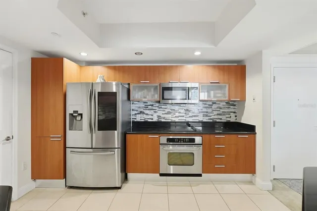 a kitchen with stainless steel appliances granite countertop a refrigerator and a stove