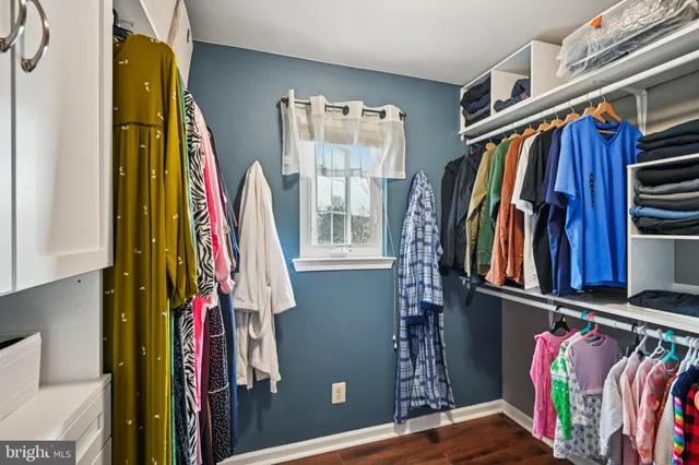 a view of walk in closet with clothes and shoes