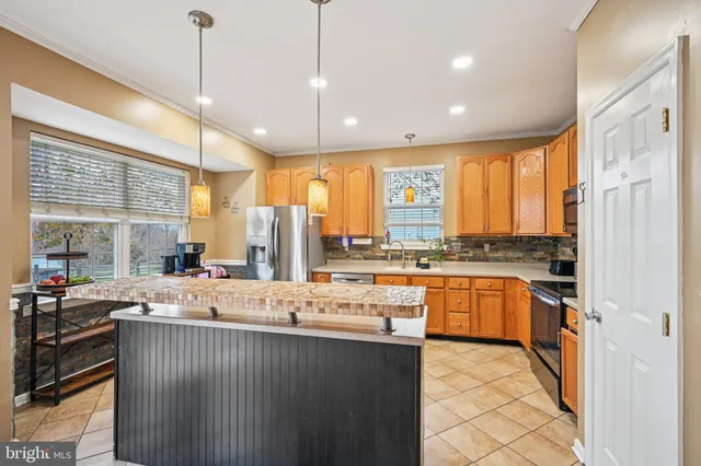 a kitchen with stainless steel appliances granite countertop sink stove and refrigerator