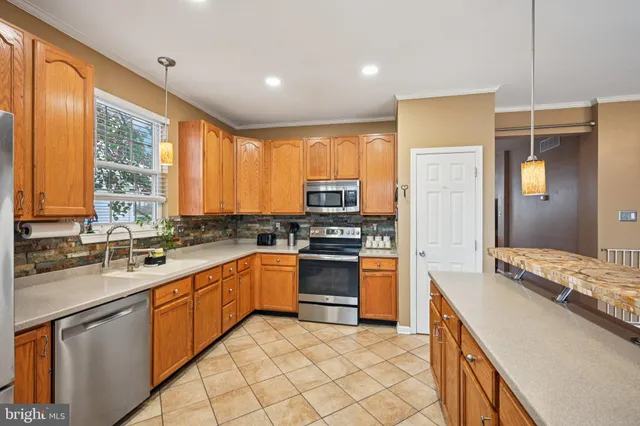 a kitchen with a sink stove top oven and refrigerator