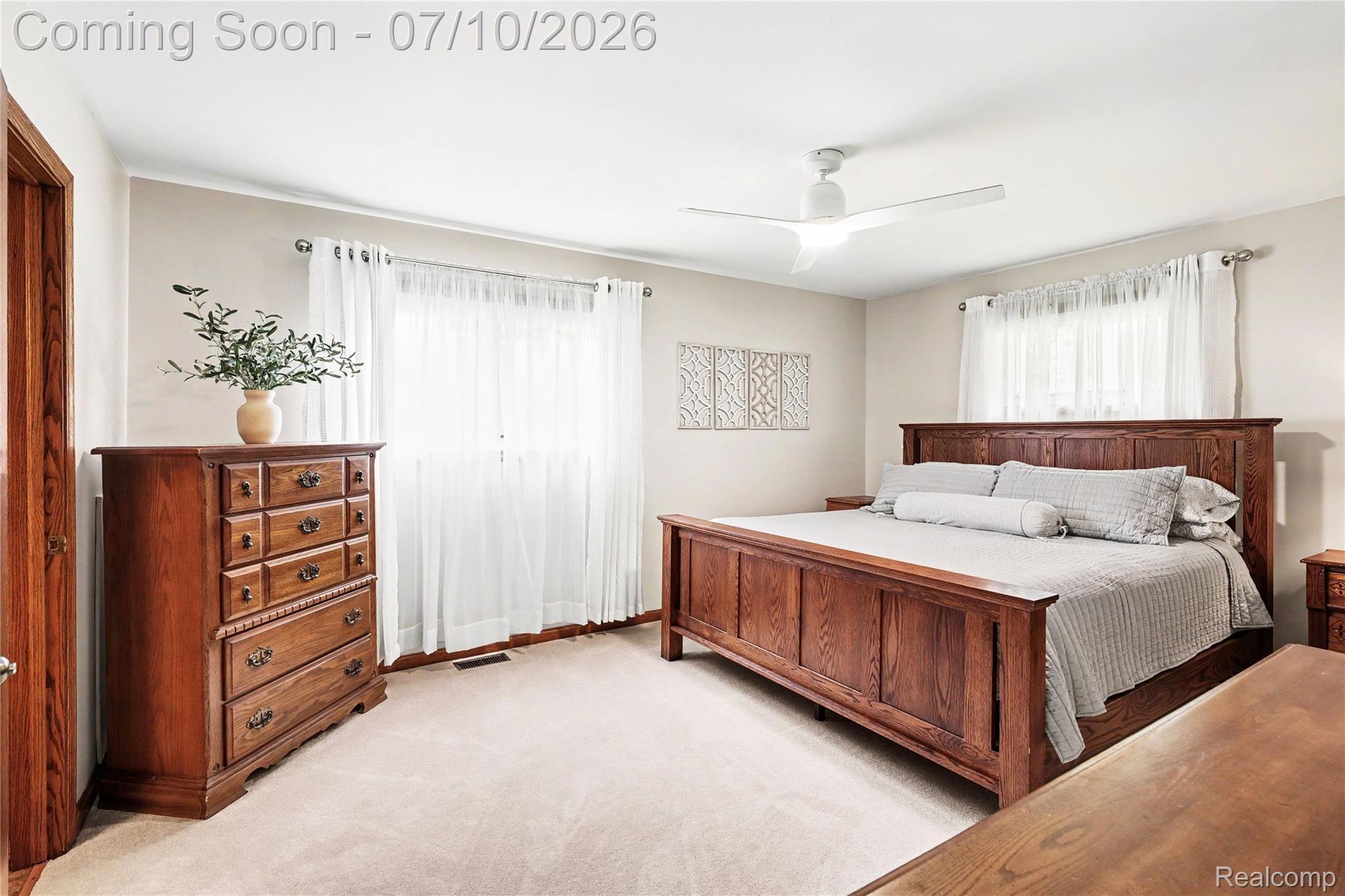 2180 Hurst Road St. Clair, MI 48079 - Photo 18 of 39 Carpeted bedroom featuring a modern ceiling fan with integrated lighting, multiple windows with white sheer curtains, and light neutral wall colors