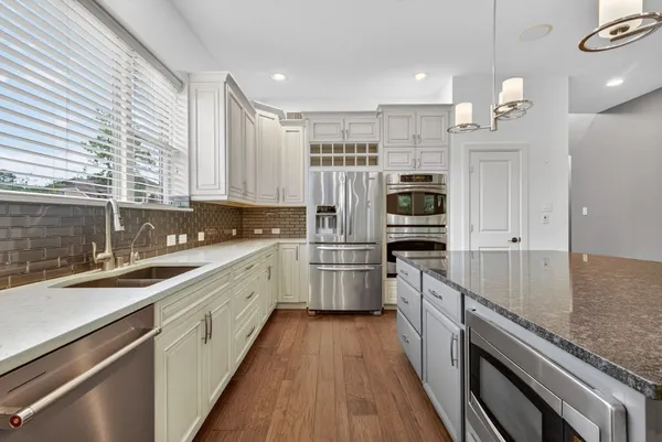 a kitchen with kitchen island granite countertop a sink appliances cabinets and counter space