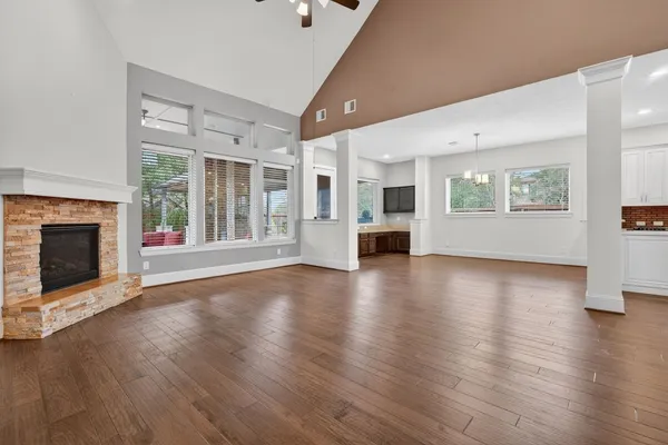an empty room with wooden floor and a fireplace