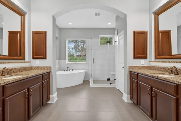 a bathroom with a tub sink and mirror