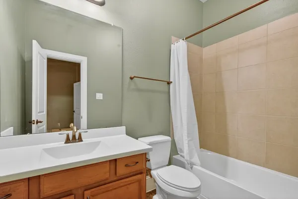 a bathroom with a sink a toilet a mirror and shower