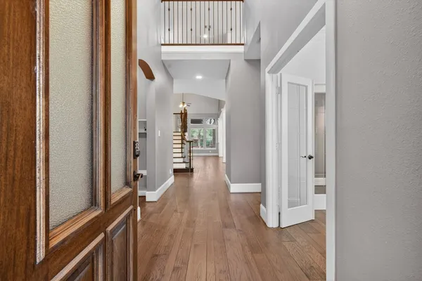 a view of a hallway with wooden floor and staircase