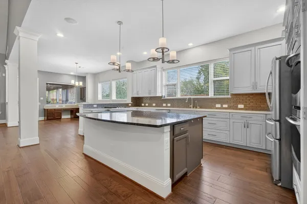 a kitchen with granite countertop a sink cabinets and wooden floor