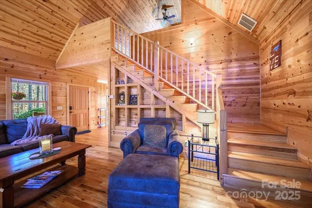 a dining room with wooden floor a chandelier a wooden table and chairs