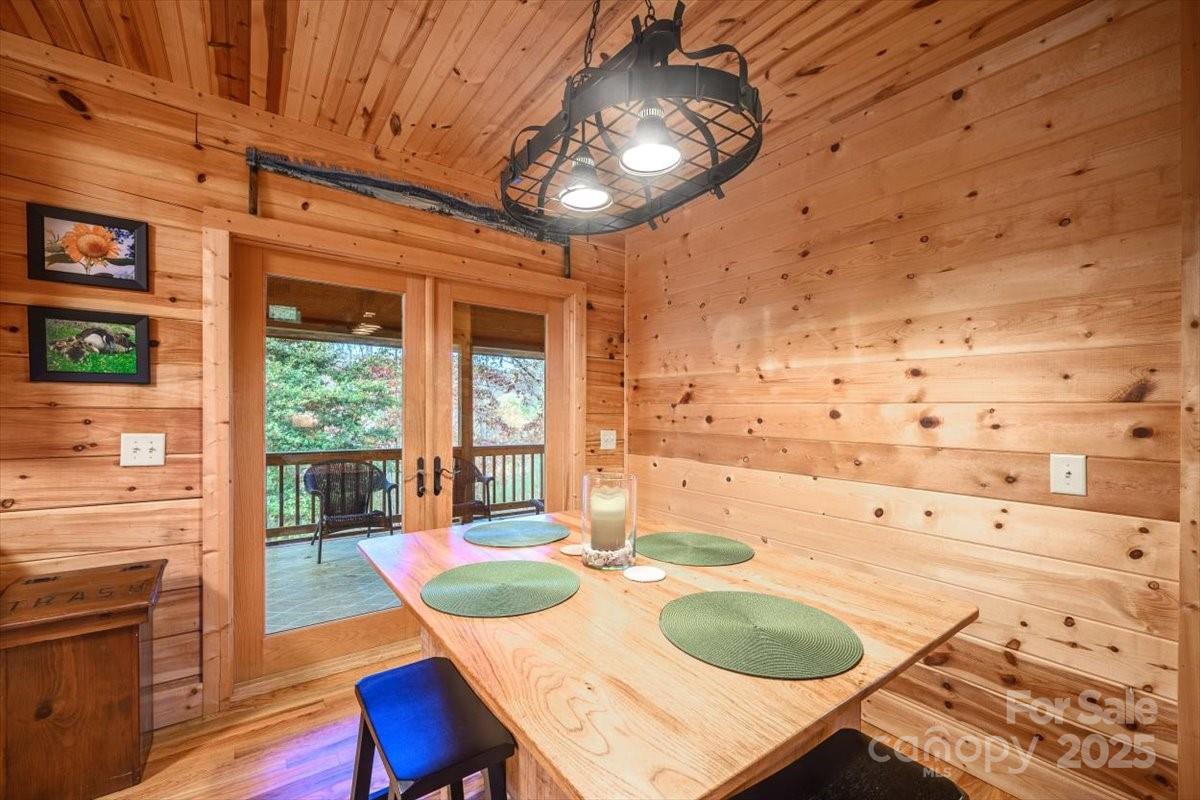 87 Prater Cove Road Franklin, NC 28734 - Photo 22 of 34 a dining room with wooden floor a chandelier a wooden table and chairs