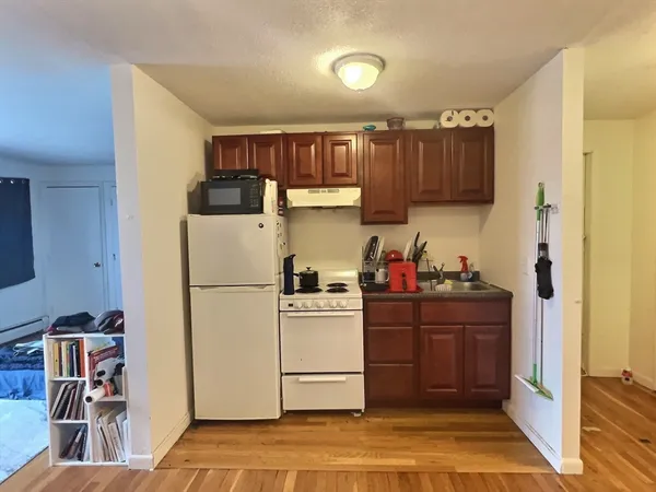 a kitchen with a refrigerator and a stove top oven